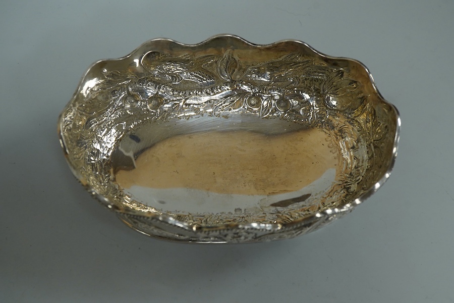 A late Victorian embossed silver oval bowl, decorated with birds, fruit and foliage, Charles Stuart Harris, London, 1889, length 14.3cm, 5.6oz.